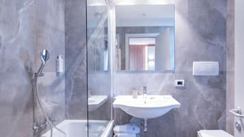 Une salle de bain moderne avec une douche à parois de verre, un lavabo blanc et des toilettes.