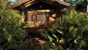 A small, wooden structure with a sloped roof surrounded by dense tropical vegetation. - Sunset at the Palms Resort - Adults Only - All Inclusive (Negril)