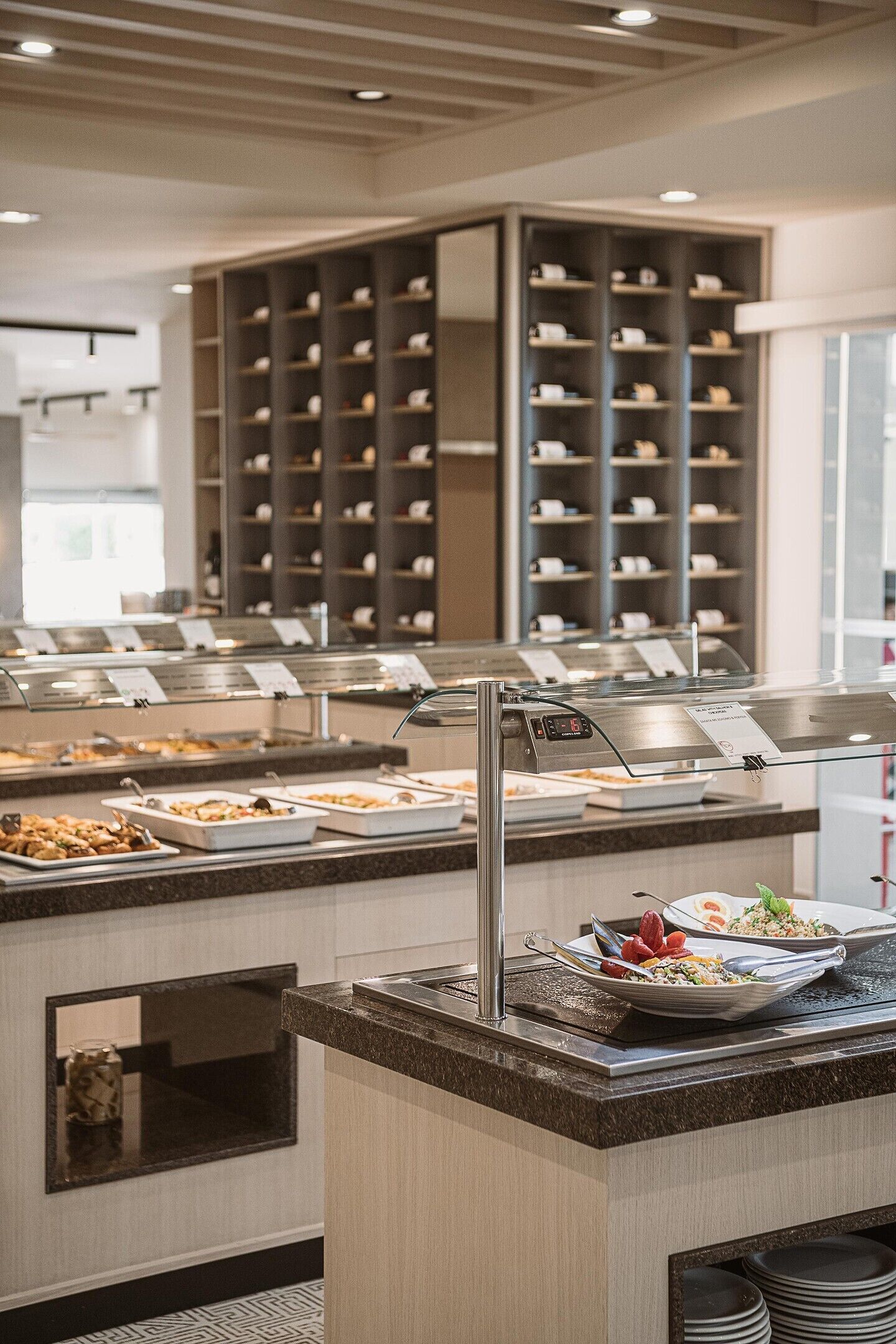 A buffet area with multiple serving stations, a digital clock, and a variety of food options.