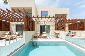 A pool area with wooden loungers, a ladder, and a pergola structure. - Sirios Village Hotel & Bungalows - All Inclusive (Chania)