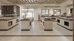 Un vestíbulo de hotel moderno con una isla central, vitrinas de vidrio y un suelo estampado.