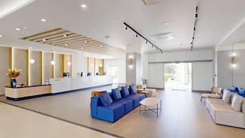 A modern reception area with a reception desk, seating arrangements, and a large glass door leading outside.