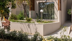 Una casa moderna de dos pisos con un patio, mobiliario exterior y una pérgola.