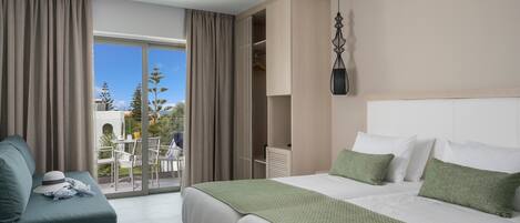 A hotel room with a bed, a seating area, a ceiling fan, and a view through the window.