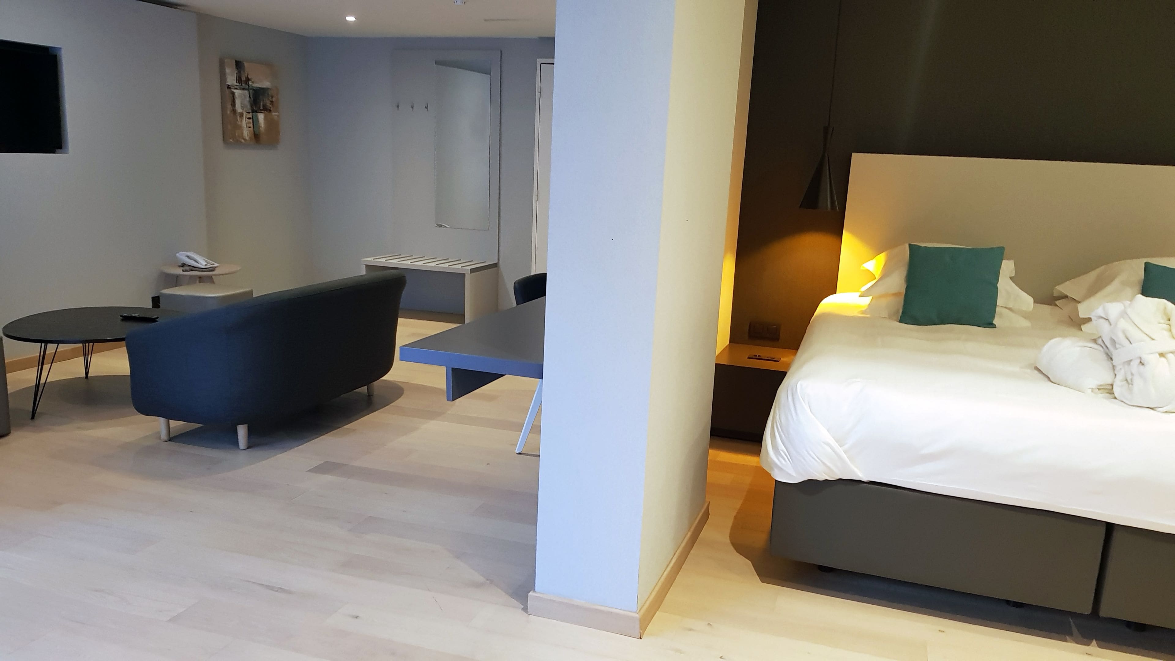 Une chambre d’hôtel moderne équipée d’un lit, d’un bureau, d’une chaise et d’une petite table.