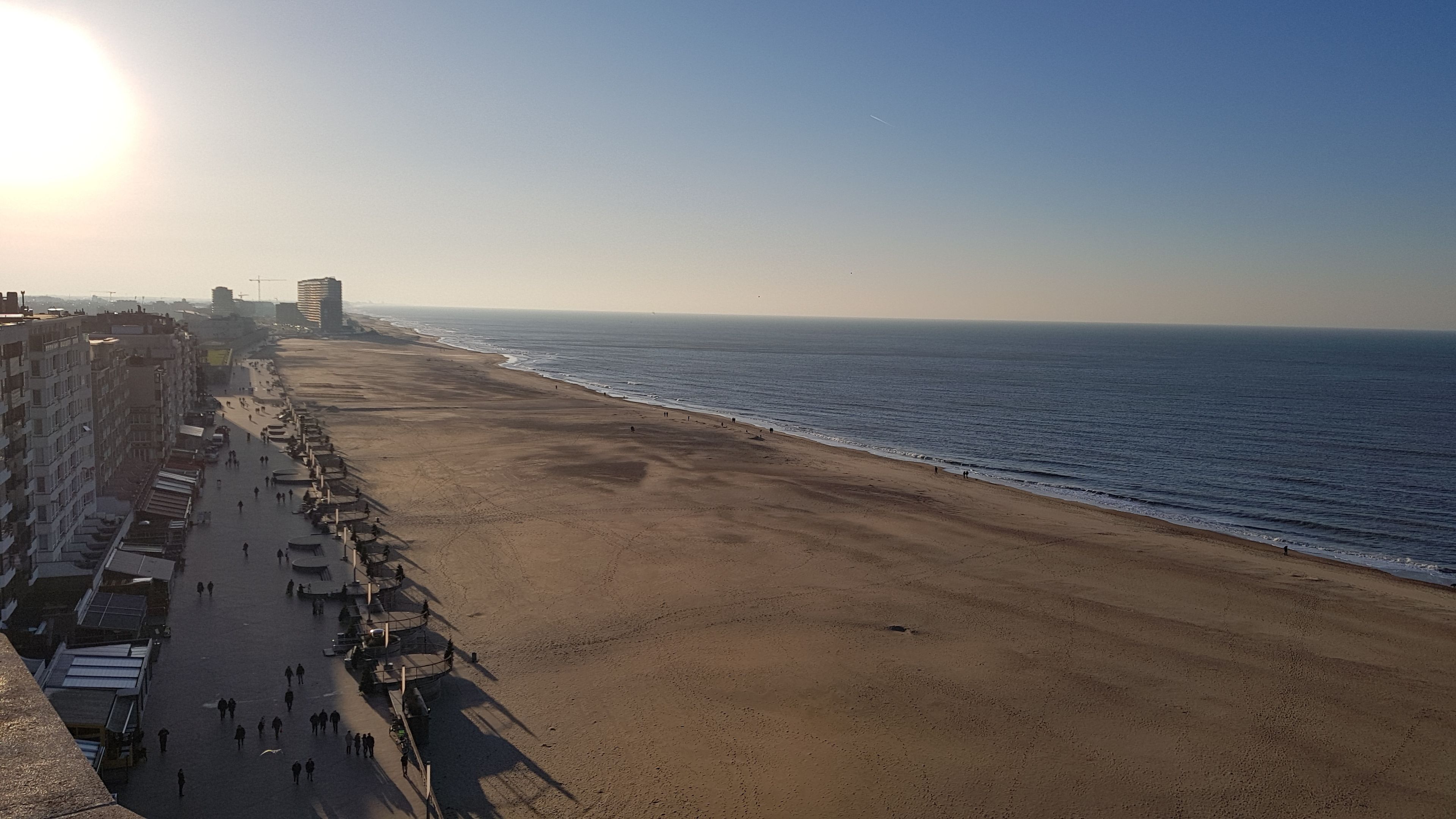 Une plage bordée d’une promenade où s’alignent des immeubles et des boutiques.
