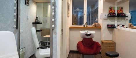Un baño moderno con tocador, lavamanos y espejo con iluminación.