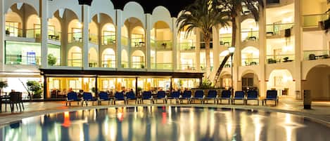 Een buitenzwembad, parasols bij het zwembad en ligstoelen