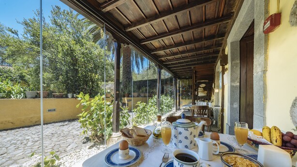 A breakfast table set with bread, eggs, coffee, and fruit. - Hotel Rural las Calas (Vega de San Mateo)