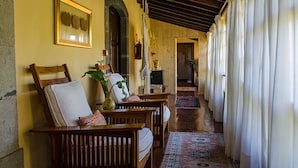 A cozy hallway with wooden furniture, a patterned rug, and a framed botanical print on the wall. - Hotel Rural las Calas (Vega de San Mateo)