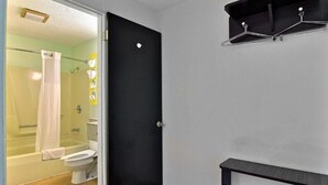 Une salle de bain avec une douche, des toilettes et une porte noire.