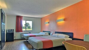 Une chambre d’hôtel avec deux lits, une table à manger et un four à micro-ondes.