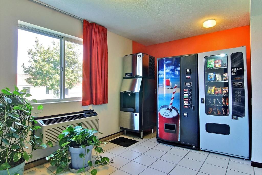 A room with a window, a water dispenser, a vending machine, and a radiator.