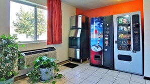 Una habitación con ventana, dispensador de agua, máquina expendedora y radiador.