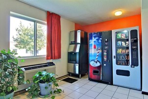 Una habitación con ventana, dispensador de agua, máquina expendedora y radiador.