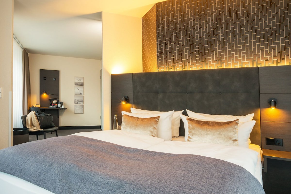 Una habitación de hotel con una cama grande, un escritorio y una silla.