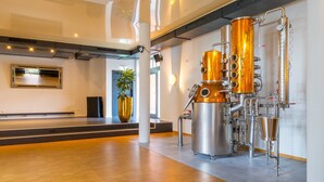 Un intérieur moderne avec un grand appareil de distillation brillant, un grand vase doré et un plancher en bois.