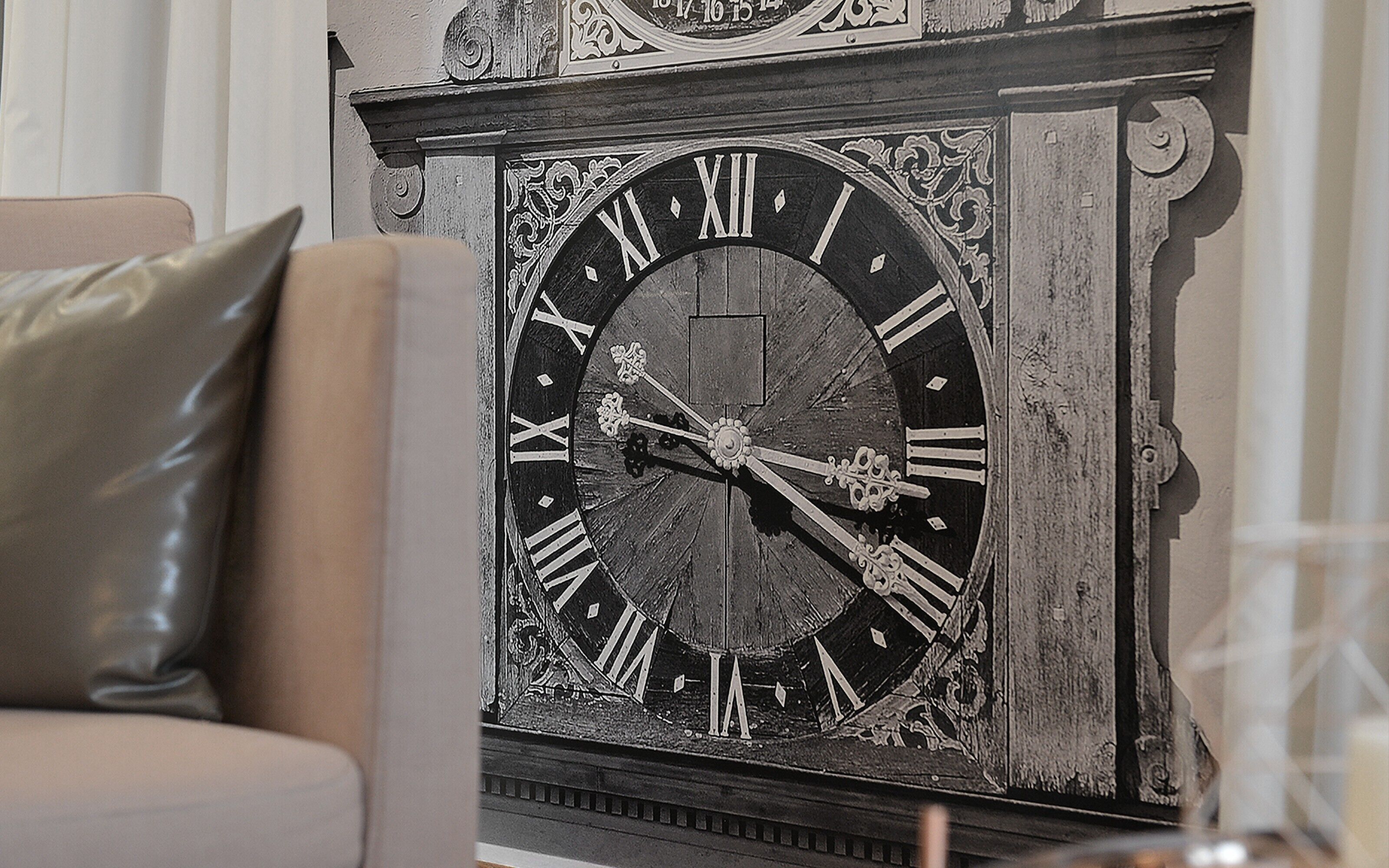 A large, ornate wall clock with Roman numerals and intricate designs.