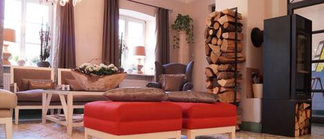 A cozy living room with a fireplace, comfortable seating, and a decorative plant.