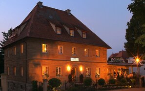A stone building with a tiled roof, multiple windows, and a sign indicating it is a restaurant. - Villa Mittermeier Hotellerie & Restaurant (Rothenburg ob der Tauber)