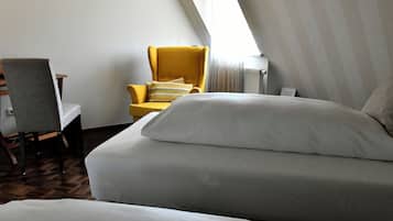Habitación de hotel con cama, una silla y ventana.
