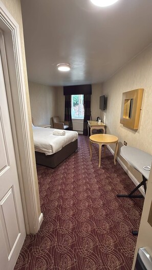 A hotel room with a bed, a small table, a chair, a desk, and a television. - Wrexham Llyndir Hotel by Belvilla (Wrexham)