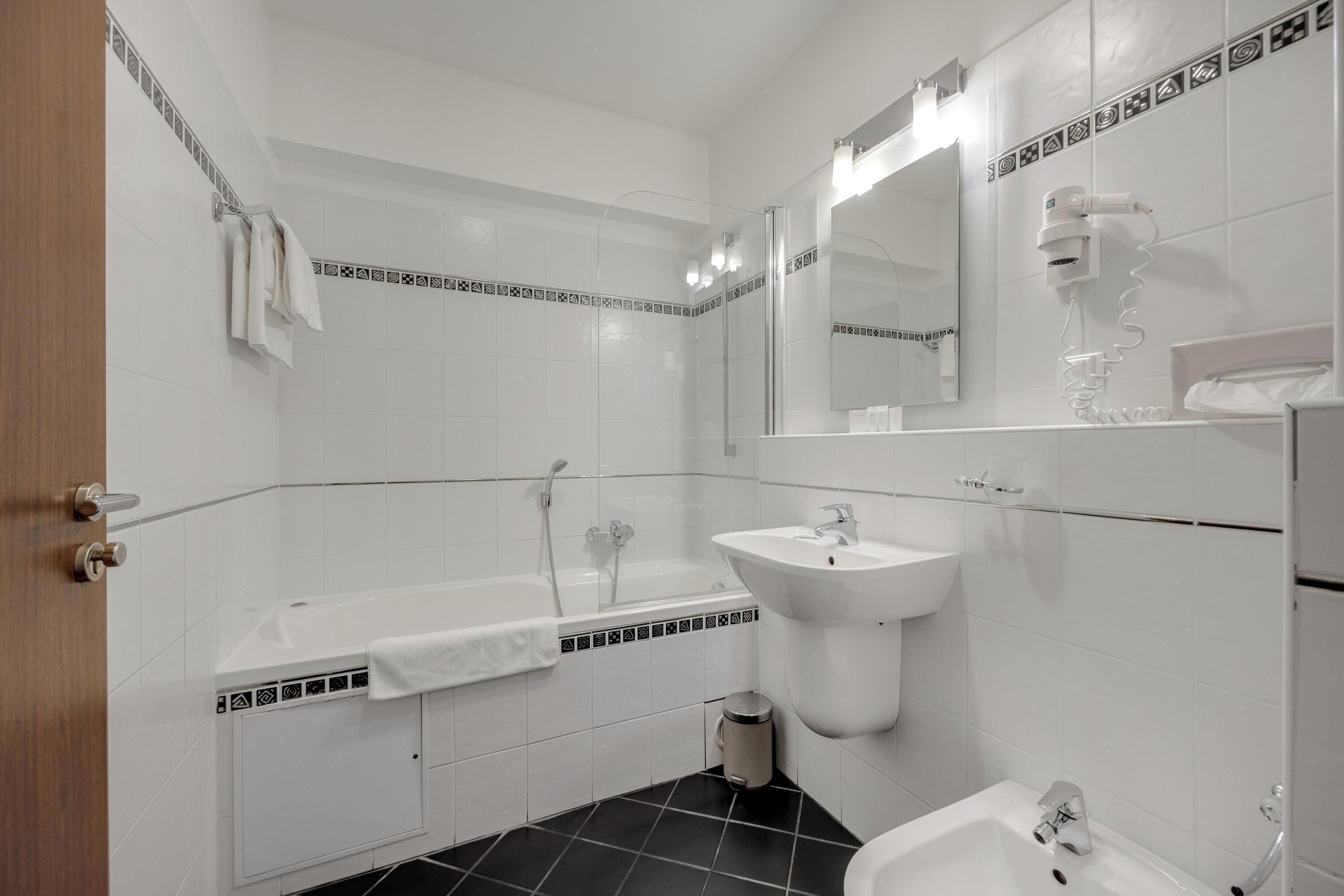 Une salle de bain moderne équipée d’une baignoire, d’un lavabo et d’un bidet.