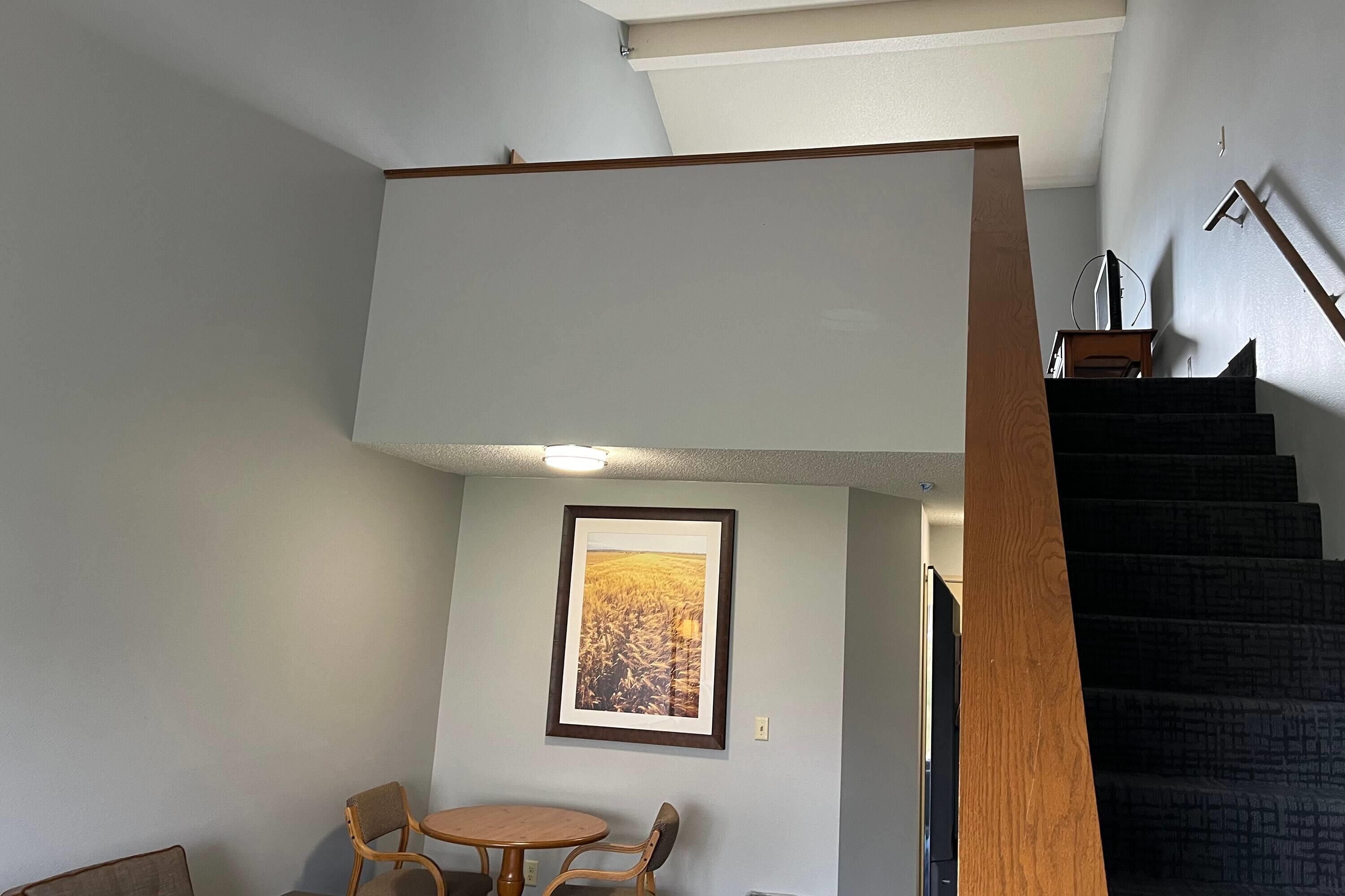 A staircase with a wooden handrail leading to a landing.