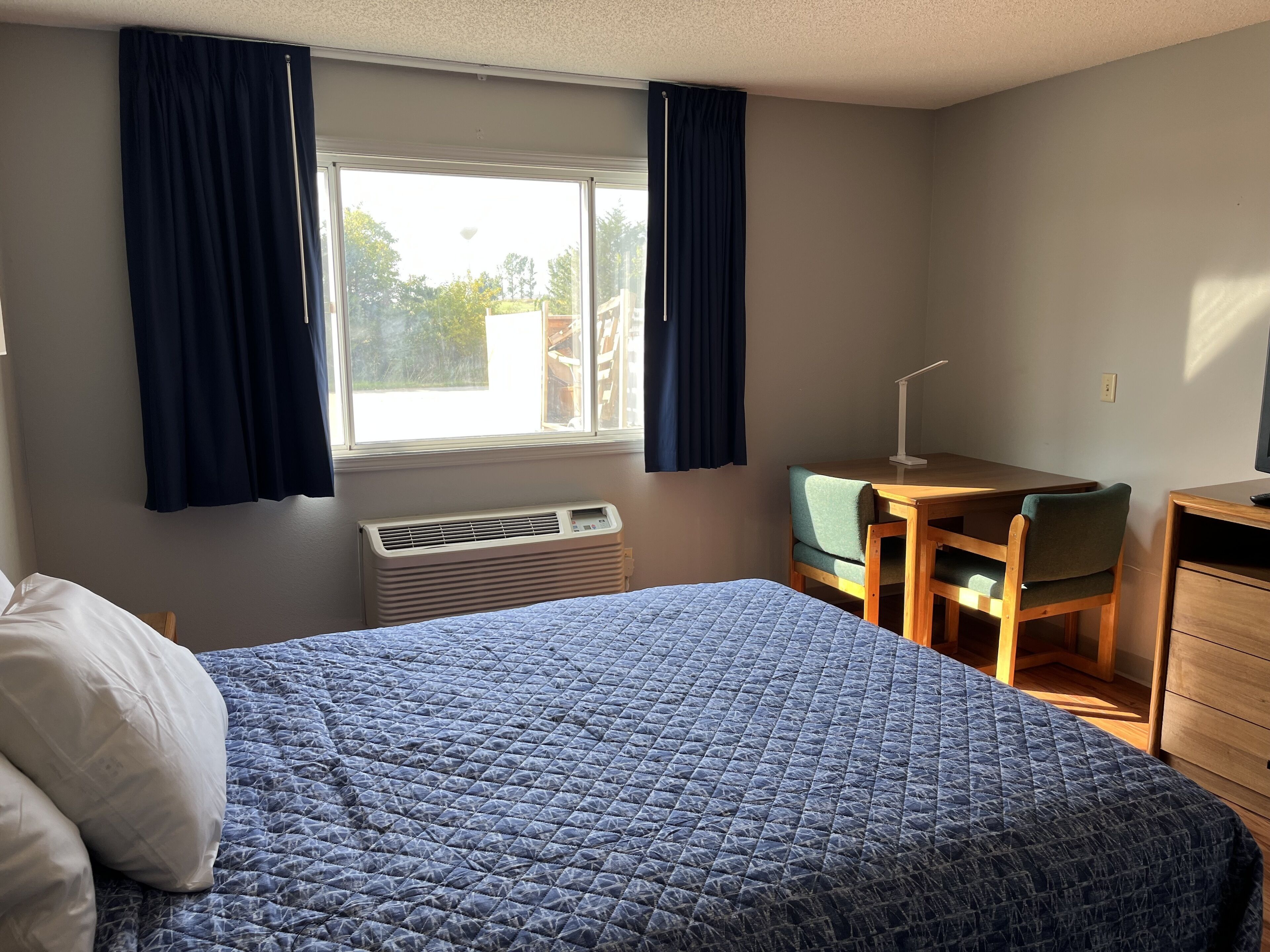 Un dormitorio con una cama, un escritorio y una silla.
