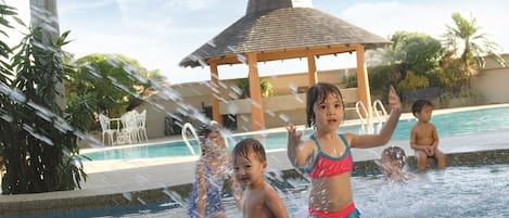 A pool area with a gazebo, palm trees, and a water fountain.
