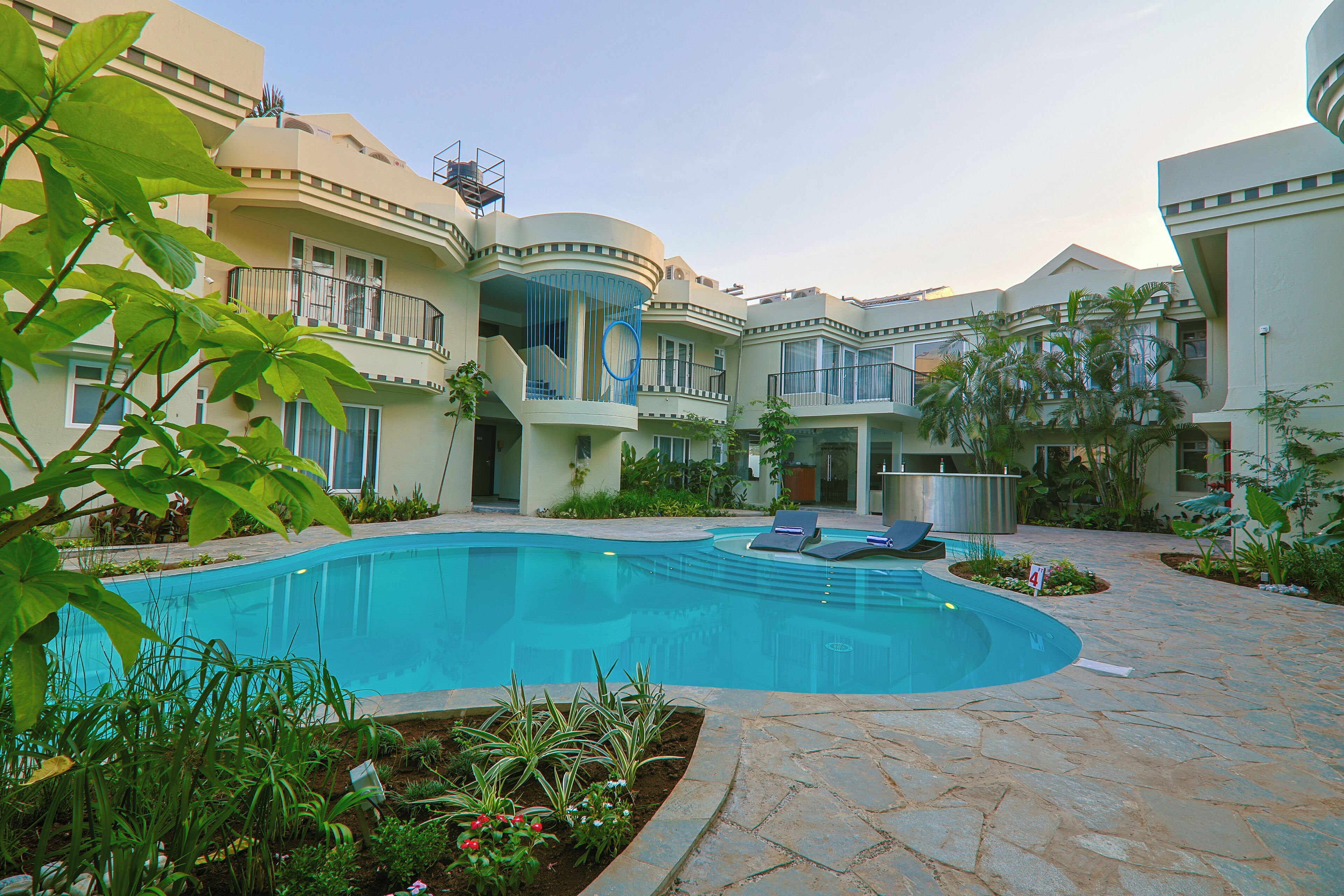 A pool area with a curved pool, lounge chairs, and a landscaped garden.