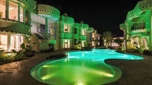 A resort with a swimming pool, multiple balconies, and a well-lit exterior. - The Orchid Passaros Goa - Adults Only Resort (Benaulim)