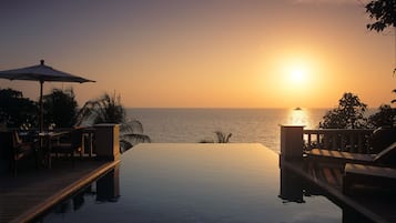Una piscina al aire libre, sombrillas, tumbonas