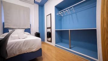 Een slaapkamer met een bed, een kledingkast, een spiegel en een hangroede.