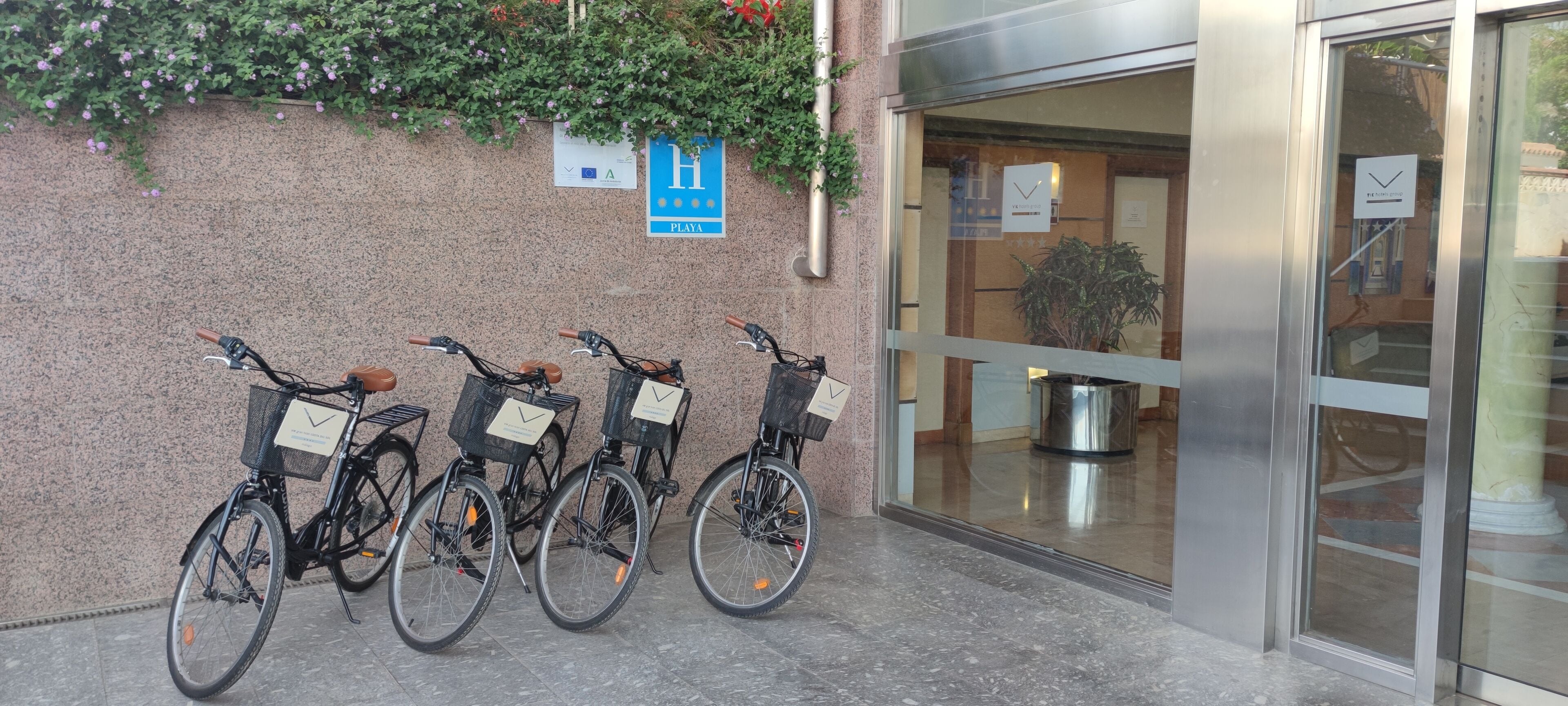 Une rangée de vélos est garée devant un bâtiment sur lequel est apposée une enseigne indiquant qu’il s’agit d’un hôtel.