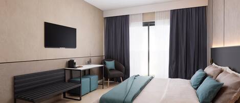 A modern hotel room with a bed, a desk, a chair, and a bench.