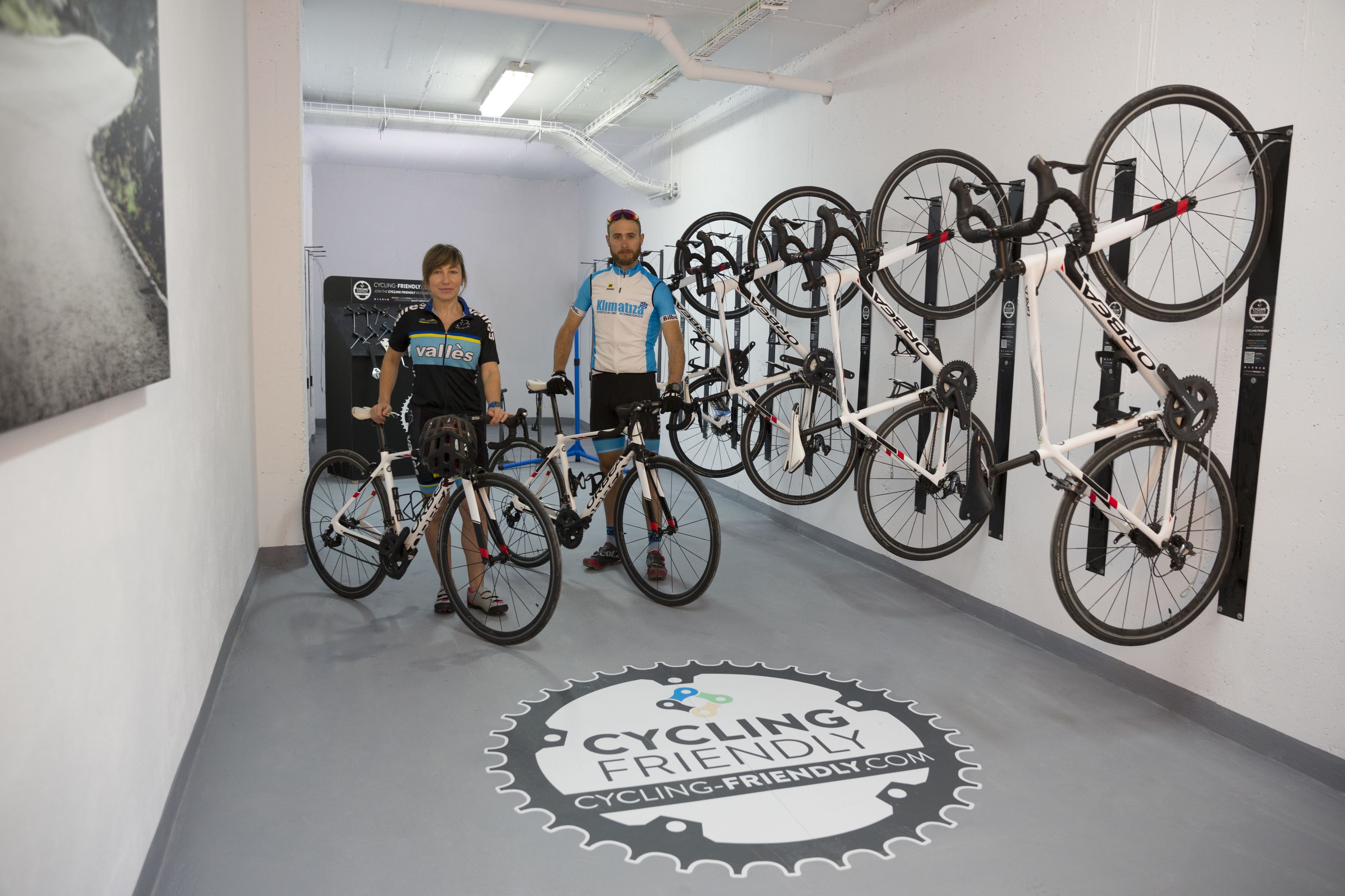 A cycling-themed room with bicycles mounted on the wall and a logo on the floor.