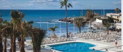 Una piscina cubierta, una piscina al aire libre, sombrillas, tumbonas