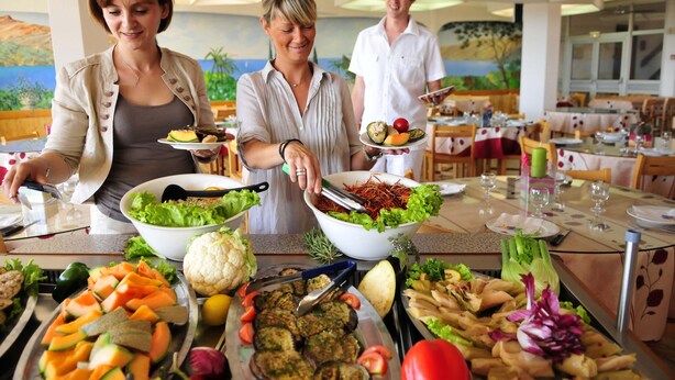 A buffet setup with various dishes and salads.