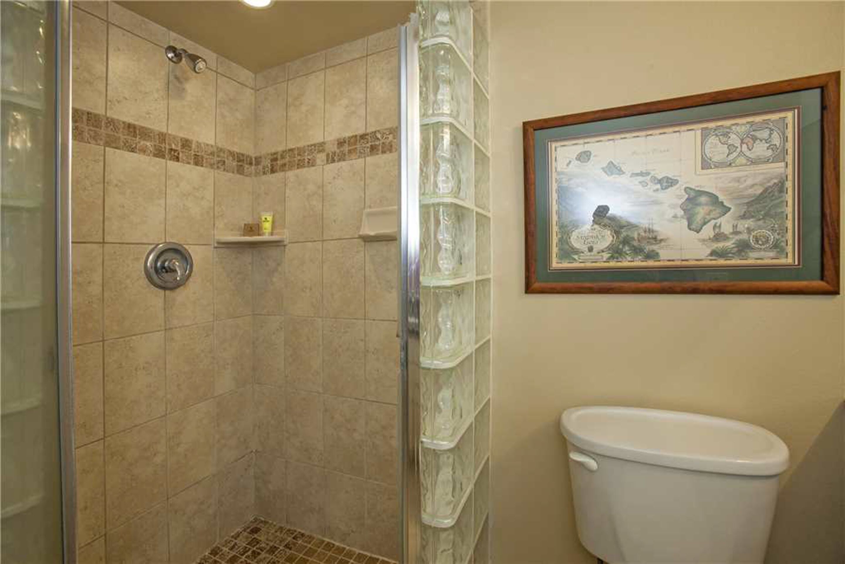 Ein Badezimmer mit Dusche, Toilette und einer an der Wand hängenden Karte.