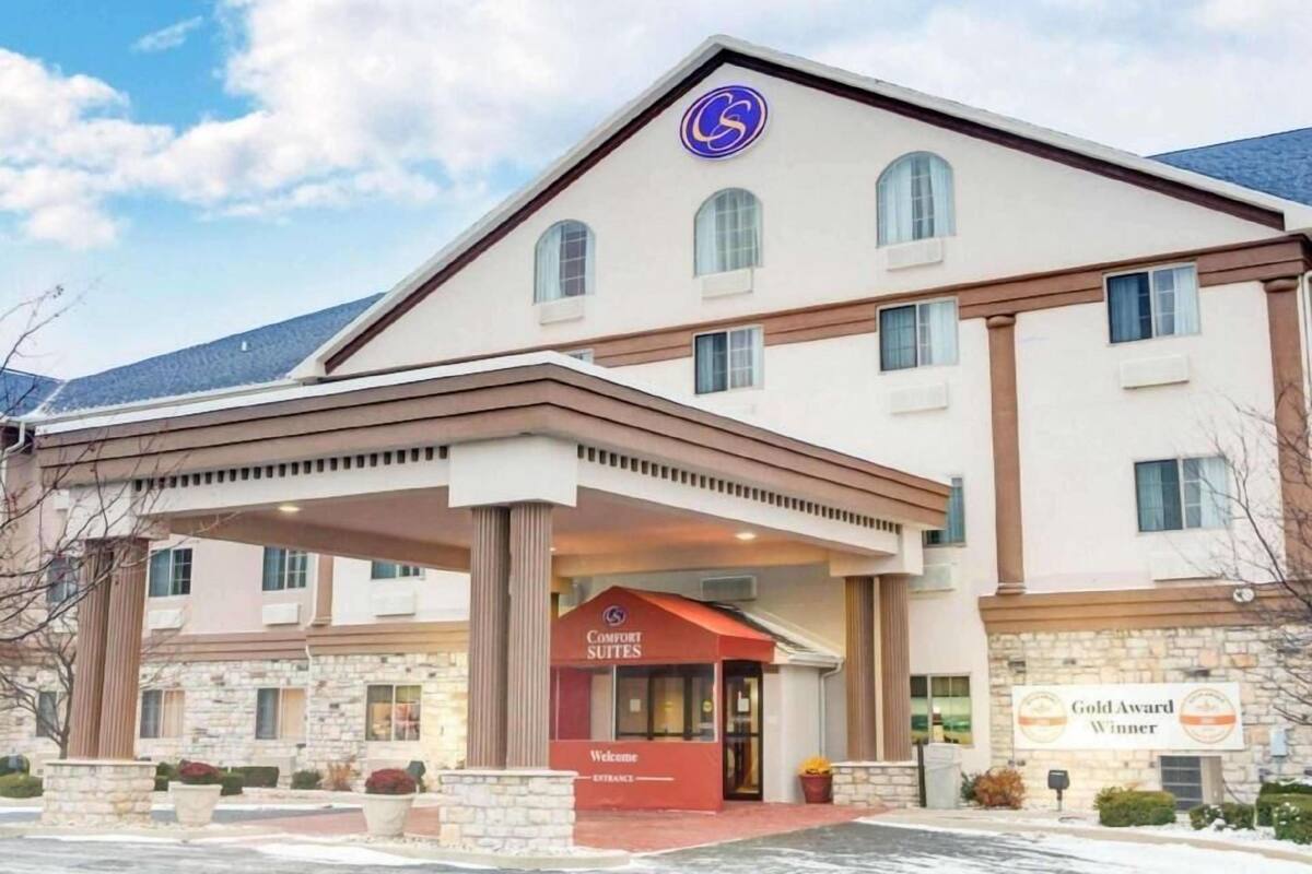 Un hôtel doté d’une entrée couverte, d’une enseigne indiquant « Comfort Suites » et d’une autre mentionnant qu’il a reçu un « Prix d’or ».