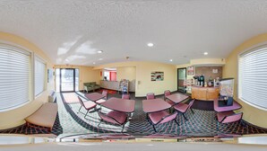A panoramic view of a hotel lobby with a seating area, a reception desk, and a kitchenette. - Econo Lodge Lincoln (Lincoln)
