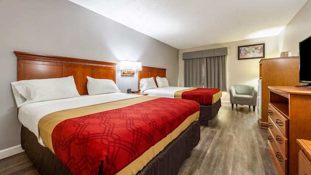 A hotel room with two beds, a TV, a desk, and a chair. - Econo Lodge Lincoln (Lincoln)