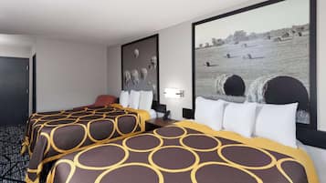 Ein Hotelzimmer mit zwei Betten, einem großen gerahmten Bild von Heuballen und einem Telefon auf dem Nachttisch.