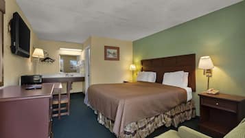 A hotel room with a bed, desk, chair, and a television mounted on the wall.