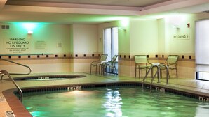 En swimmingpool med et forbud mod dykning, liggestole og et skilt om livredderberedskab.