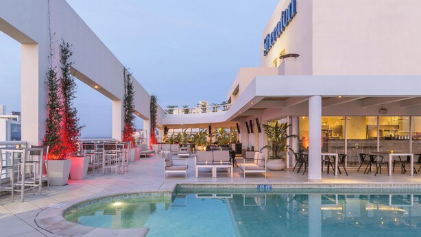 A rooftop pool area with lounge seating and a bar. - Sheraton Asuncion Hotel (Asuncion)