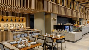 A modern dining area with a buffet setup, a coffee station, and a counter with a sign reading "A More by Sheraton." - Sheraton Asuncion Hotel (Asuncion)
