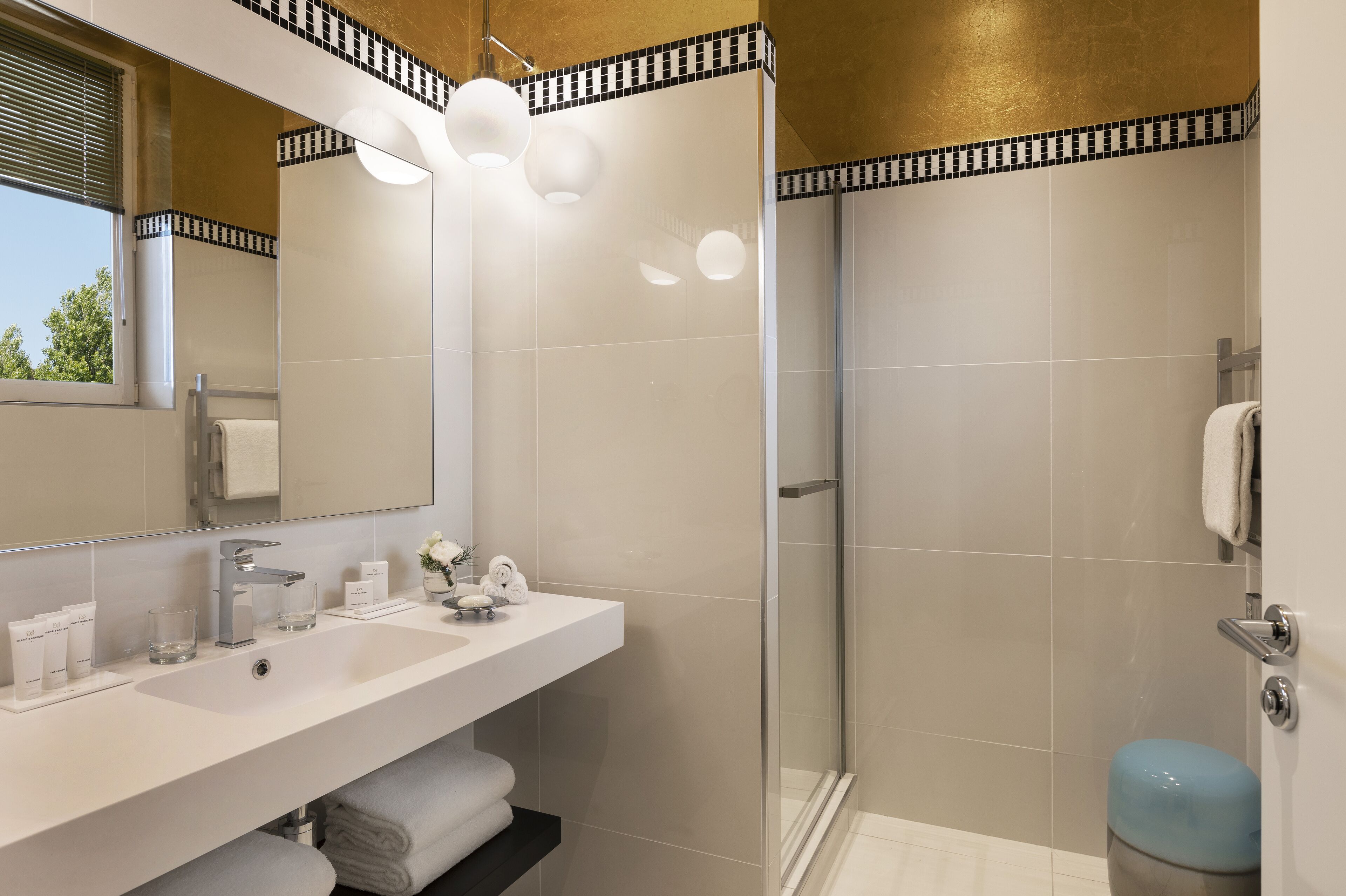 Een moderne badkamer met een grote spiegel, een witte wastafel en een douchecabine van glas.
