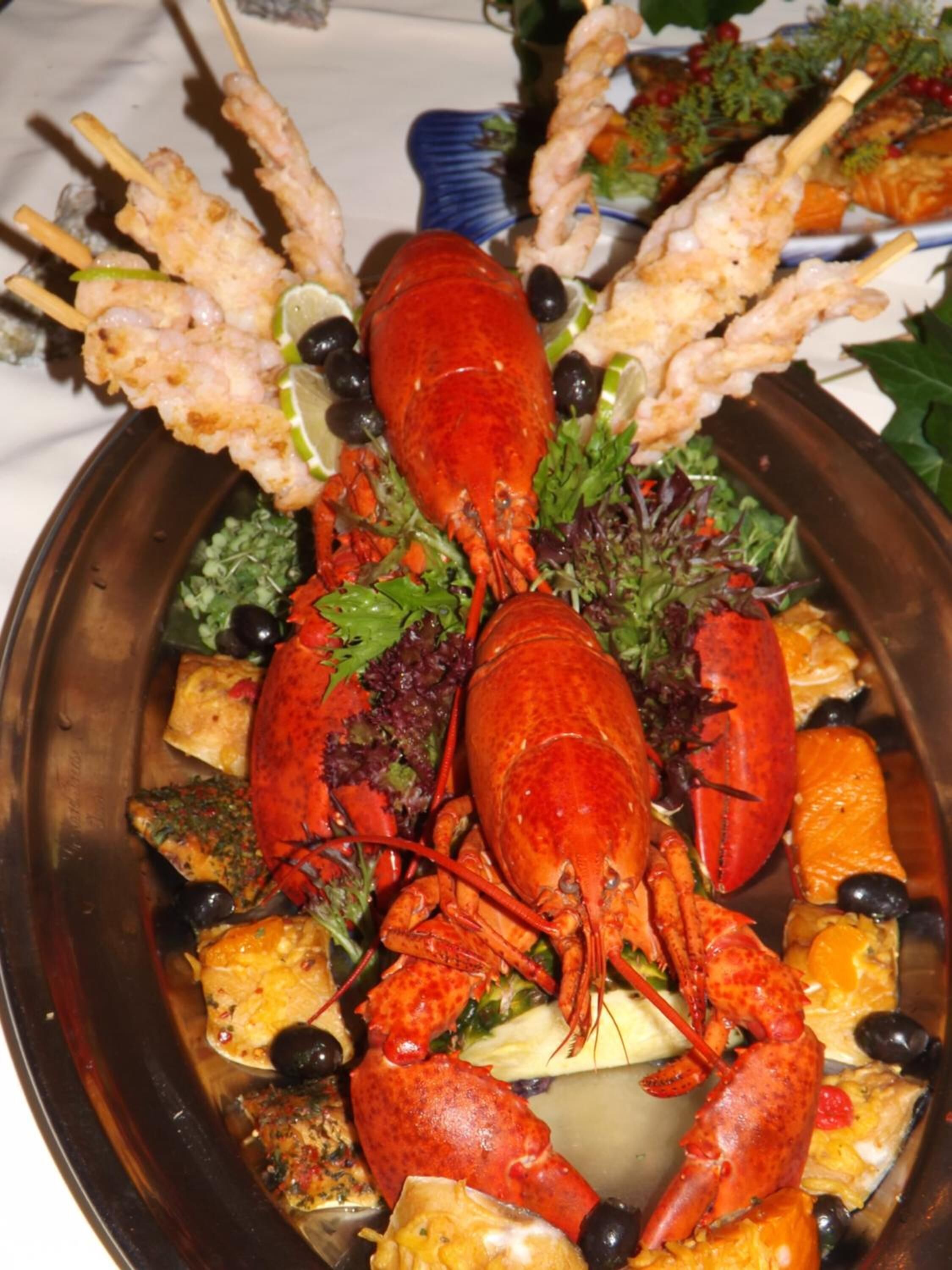 A lobster dish with skewers and vegetables.
